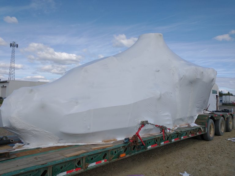Large industrial equipment shrink-wrapped for transport in Alaska, providing weather-resistant protection during shipping and storage in harsh conditions