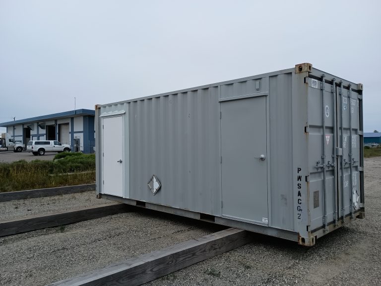 Modified shipping container with personnel doors installed in Alaska, used for secure storage, utility space, or remote job site support